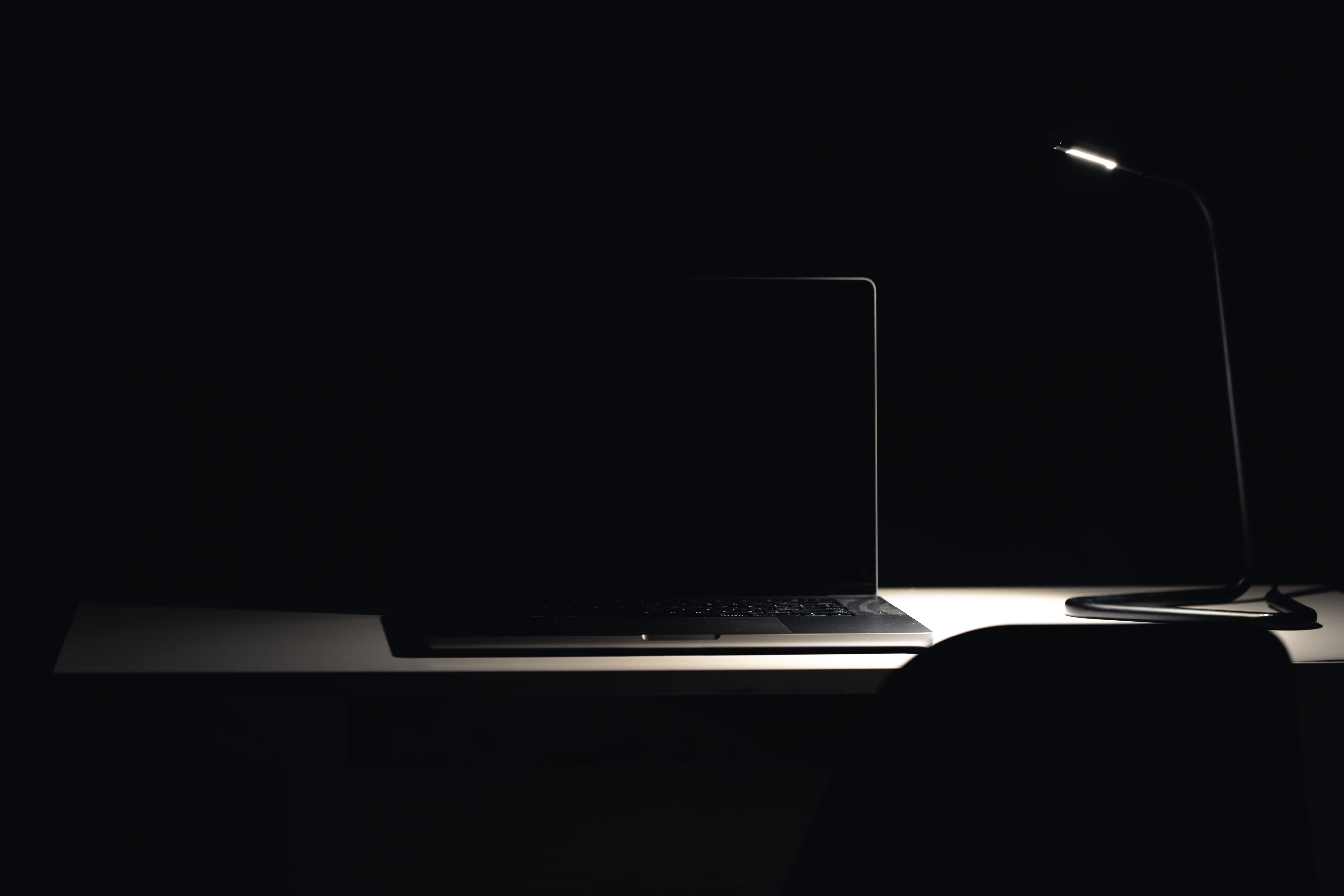 Black laptop in dark room